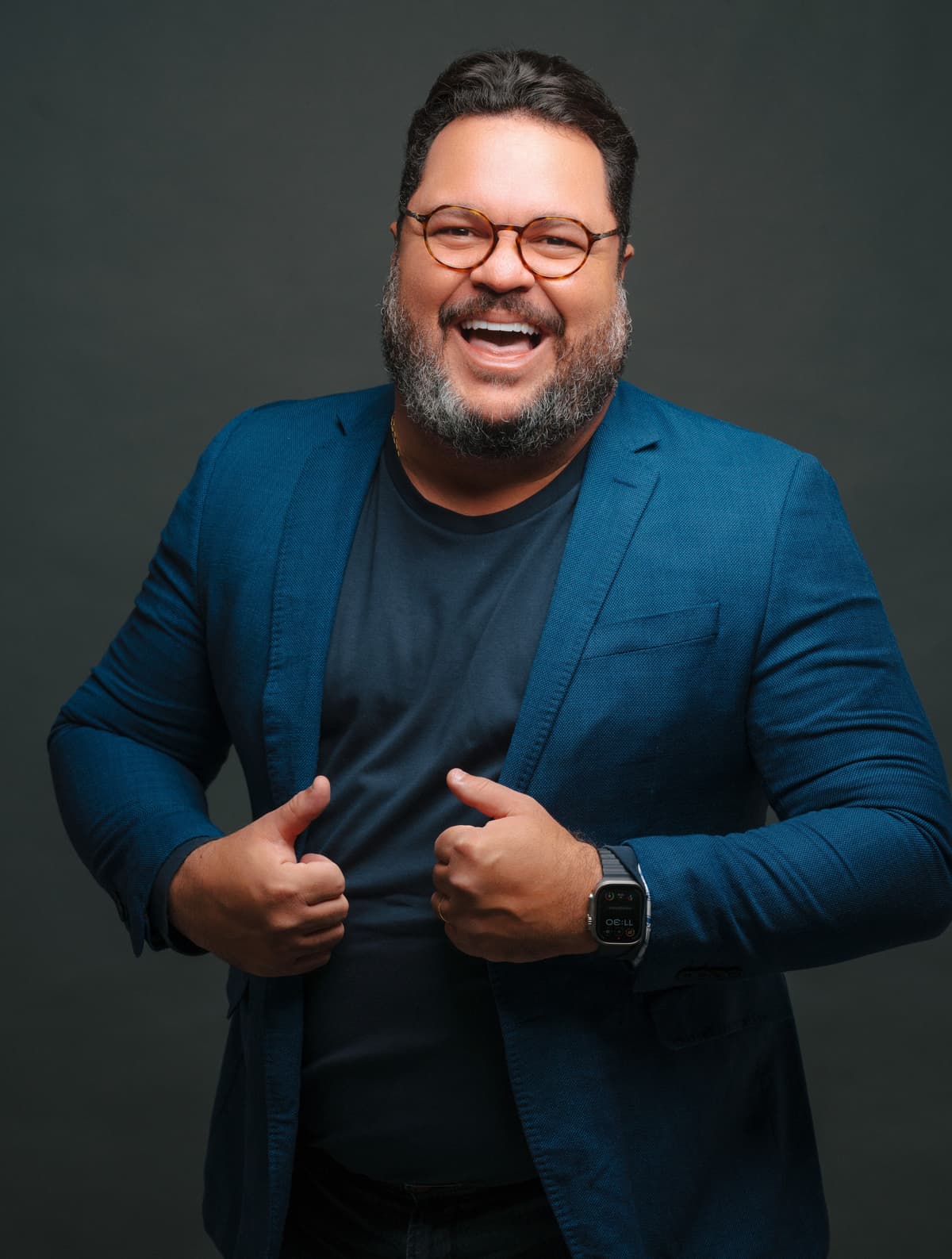 Evento Super Megavendas para concessionárias Um painel digital em cinza e preto com um homem sorridente de óculos, barbudo e camisa social azul. Ele aponta para o centro do painel, onde há vários cartões com textos como 'Equipe engajada', 'Clientes agendados' e 'Meta de vendas batida!'. Na parte inferior, há botões com os textos 'Ligar para cliente', 'Chamar no WhatsApp', 'Agendar tarefa', 'Registrar novo contato' e 'Ver convite'.